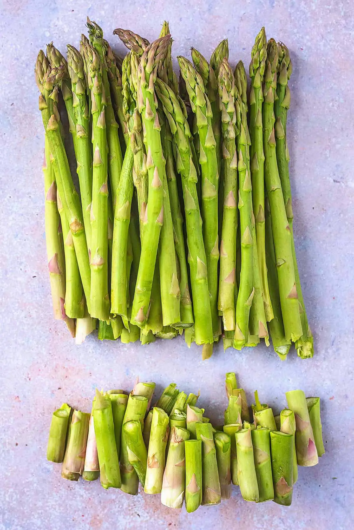 A pile of asparagus with all their woody ends snapped off.