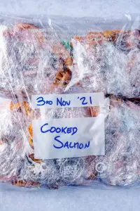 Portions of salmon in a freezer bag with a label and date written on it.